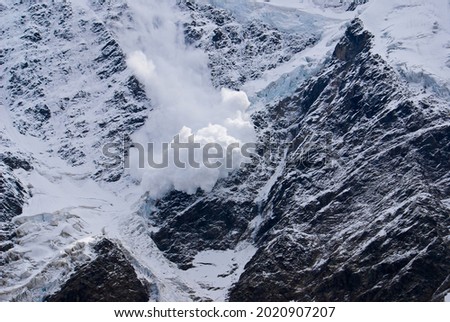 An avalanche breaks down from a steep mountain slope in the North Caucasus. Mount Donguzorun, glacier Seven