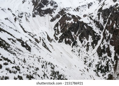 Avalanche on top of the mountain when winter changes to spring. Aerial view of some big avalanches trails. Danger for hiking. - Shutterstock ID 2151786921