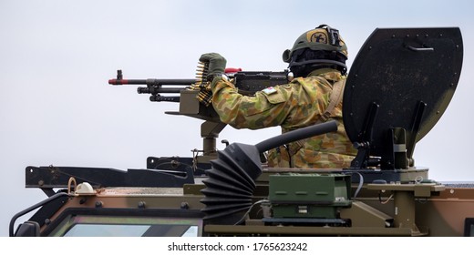 Avalon, Australia - February 27, 2015: Australian Army Soldier With Large Machine Gun In The Turret Of A Bushmaster Armoured Personnel Carrier (APC).