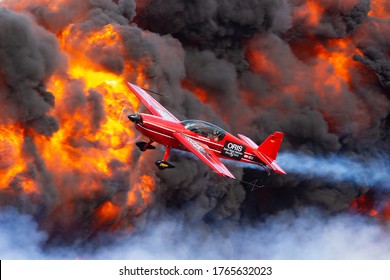 Avalon, Australia - February 28, 2015: Aerobatic pilot Melissa Pemberton (Melissa Andrzejewski) flying an Extra 300 aerobatic aircraft past a pyrotechnics explosion. 