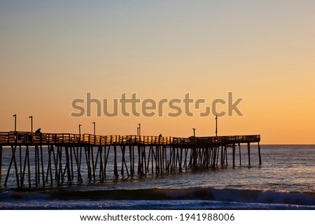 Avalon fishing Pier in the Outer Banks of North Carolina is picturesque at sunrise.  This is a popular vacation destination along the coast.