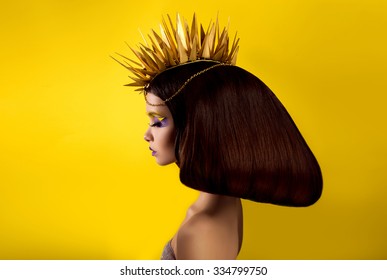 The avantaged portrait
girl with an unusual make up looking at the camera,
Portrait on a yellow background, custom volume hairstyle metal ornament in the form of fragments,fashionable toning - Shutterstock ID 334799750