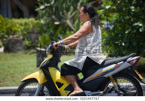 AVARUA, COOK ISLANDS - FEBRUARY 5,\
2009: Mature Woman Riding Motorbike in Avarua, Cook\
Islands