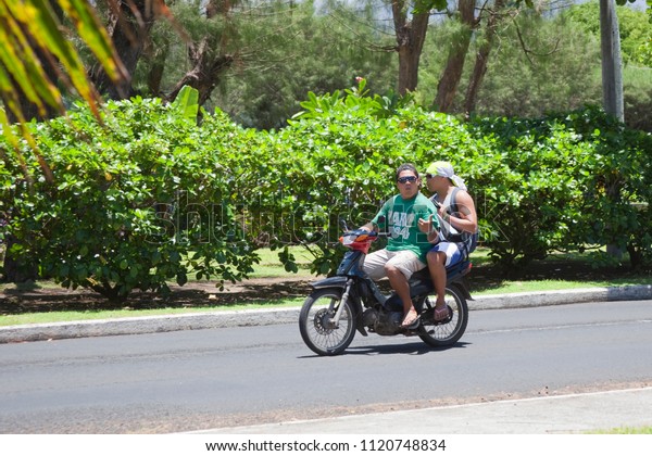 AVARUA, COOK ISLANDS - FEBRUARY 5,\
2009: Two Men Riding Motorbike in Avarua, Cook\
Islands.