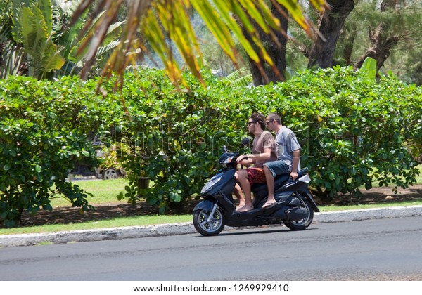 AVARUA, COOK\
ISLANDS - FEBRUARY 5, 2009: Two Men Riding Motorbike - Rarotonga,\
Cook Islands, Polynesia,\
Oceania