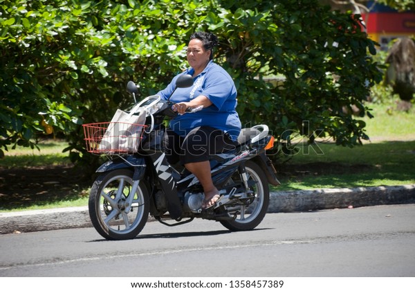 AVARUA, COOK ISLANDS - FEBRUARY 5,\
2009: Mature Woman Riding Motorbike in Avarua, Cook\
Islands.