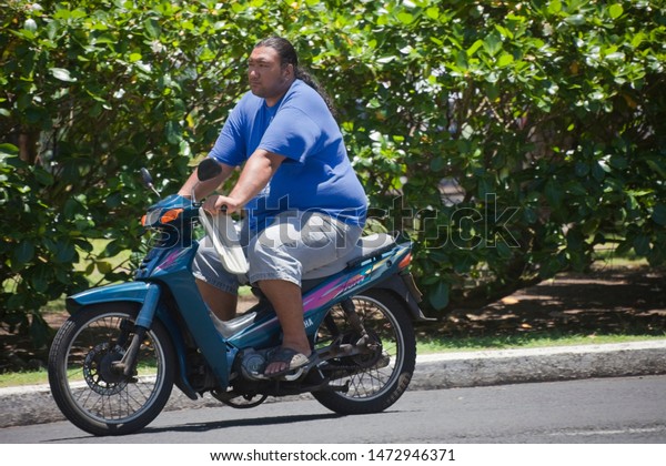 AVARUA, COOK ISLANDS - FEBRUARY 5, 2009:\
Man Riding Motorbike in Avarua, Cook\
Islands.