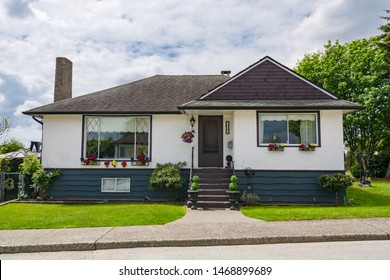 Average Family House With Green Lawn On Cloudy Day In Canada