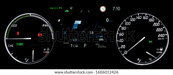 Average fuel economy consumption display between\
circular speedometer and power monitor. Illuminated car instrument\
panel with display fuel range, fuel and temperature gauge, odometer\
in hybrid car.