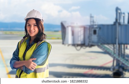 Flugsicherheit Weiblicher asiatischer Ingenieur mit Sicherheitsausrüstung mit Flughafen im Hintergrund.