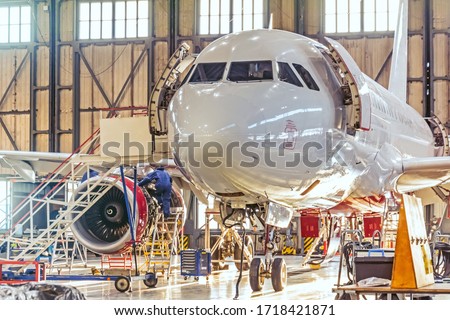 Aviation hangar and repairable passenger aircraft. Work mechanics on maintenance parts