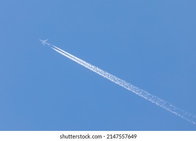 Aviation, Travel By Airplane, Airplane Flying On A Sunny Day, Sky Without Clouds, And Leaves A Large Jet Stream Behind