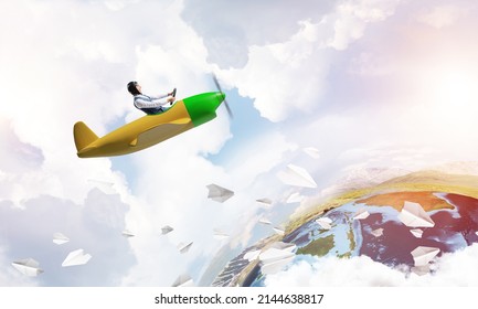 Aviator In Leather Helmet Driving Small Propeller Plane In Cloudy Blue Sky. Extreme Aviation Hobby And Free Time Activity. Funny Man Flying In Small Airplane. Earth Globe Horizon With Sea Line