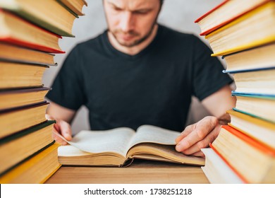 An Avid Reader - A Grown Man Flips Through Pages Of An Old Dusty Book Between Stacks Of Books In An Old Library