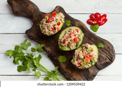 Avocado-Appetizer mit Thunfischkonserven, Glockenpfeffer, Kräuter auf Holzbrett