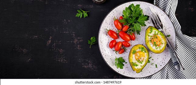 Avocado baked with egg and fresh salad. Vegetarian dish. Top view, overhead.  Ketogenic diet. Banner. Keto food