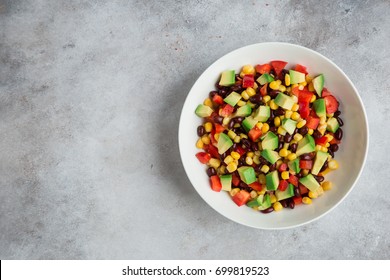 Avocado, Black  Bean, Corn And Bell Pepper Salad In White Bowl. Top View, Copy Space