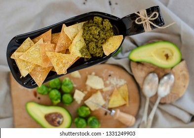 Avocado, Brussel Sprouts, Parmesan Cheese And Chips With Pesto Sauce On Unusual Serving Plate. Top View