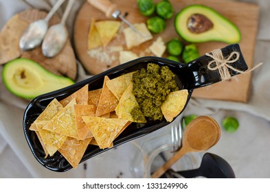 Avocado, Brussel Sprouts, Parmesan Cheese And Chips With Pesto Sauce On Unusual Serving Plate. Top View