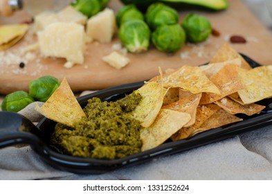 Avocado, Brussel Sprouts, Parmesan Cheese And Chips With Pesto Sauce On Unusual Serving Plate. Snaks And Healthy Food Concept. 