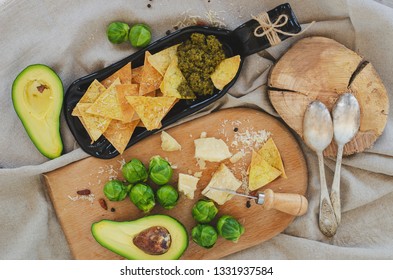 Avocado, Brussel Sprouts, Parmesan Cheese And Chips With Pesto Sauce On Unusual Serving Plate. Top View