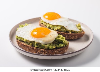 Avocado egg sandwich with a glass of water. Healthy light breakfast concept. Whole grain toasts with mashed avocado and fried eggs - Powered by Shutterstock