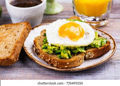 Avocado egg sandwich with whole grain bread on wooden background. Copy space - Powered by Shutterstock