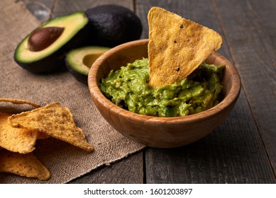 Avocado Guacamole And Tortilla Chips On Wooden Table