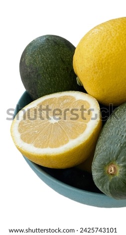 Avocado and lemons in a plate isolated on white background