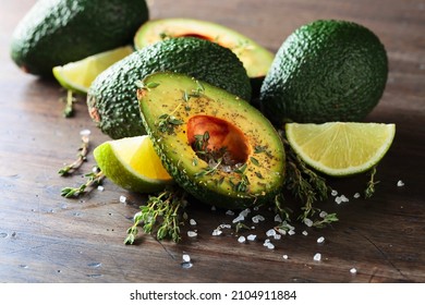 Avocado With Lime, Thyme, And Sea Salt On A Old Wooden Table.