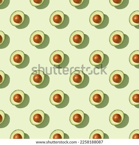 Avocado on green background pattern top view flat lay. Summer color. Minimal concept