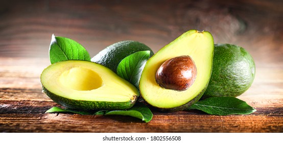 Avocado on rustic wooden table. Raw Fruits healthy green food. Avocados wide banner or panorama concept