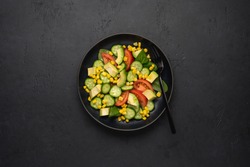 Avocado Salad With Corn, Tomatoes, Cucumbers On Black Slate Background. Top View, Copy Space