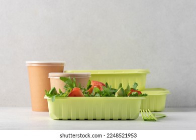 Avocado salad with tomatoes and arugula in recyclable food container. Eco food delivery concept