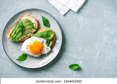 Avocado Sandwich with Fried Egg - sliced avocado and  egg on toasted bread with arugula for healthy breakfast or snack. - Powered by Shutterstock