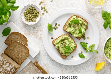 Avocado sandwich with pumpkin seeds. Healthy vegetarian avocado toast with rye bread for breakfast. Vegan menu. Top view - Powered by Shutterstock