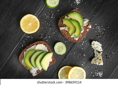 Avocado Sandwiches With Vegetables On Dark Wooden Background