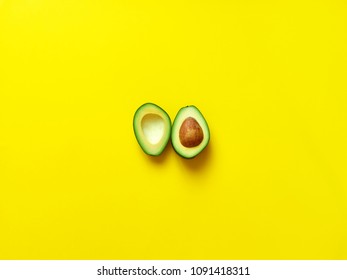 Avocado Sliced With Seed Isolated In Yellow Background Viewed From Above - Flatlay Look