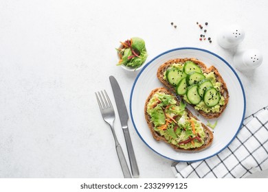 Avocado toast with cucumber, carrot and beet slices. Healthy vegan raw bread toast, top view, copy space for text or design elements - Powered by Shutterstock