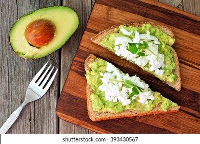 Avocado Toast With Egg Whites And Pea Shoots On Wooden Board, Overhead View