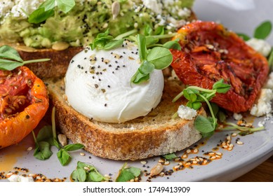 Avocado Toast Featuring Smashed Avocado, Grilled Tomatoes, Boiled Egg On Sourdough Toast