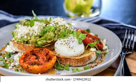 Avocado Toast Featuring Smashed Avocado, Grilled Tomatoes, Boiled Egg On Sourdough Toast