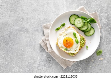 Avocado toast with fried egg for breakfast, healthy food, overhead view