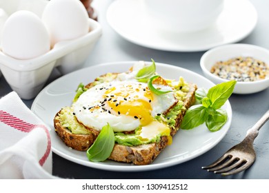 Avocado toast with fried sunny side up egg with runny yolk - Powered by Shutterstock