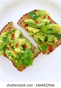 Avocado Toast Made At Home. Rye Bread With Mashed Avocado, Sriracha Sauce And Fresh Parsley Leaves. Healthy Snack. Two Toasts On A Plate, Top View, Close Up. Keto Diet Easy Recipe. Homemade.