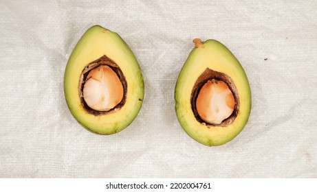 Avocados Fruit Freshly Harvested From The Tree, Cut In Half, Lay Out On Rugged White Background, 