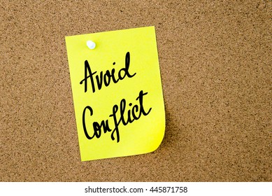 Avoid Conflict Written On Yellow Paper Note Pinned On Cork Board With White Thumbtacks, Copy Space Available