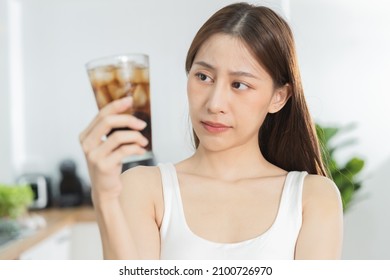 Avoid, limits sweet sugar, choose asian young woman, girl holding, looking at a glass of cold cola soft drink soda, sparkling water with ice by her hand. Health care, healthy diet lifestyle concept. - Shutterstock ID 2100726970