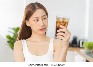 Avoid, limits sweet sugar, choose asian young woman, girl holding, looking at a glass of cold cola soft drink soda, sparkling water with ice by her hand. Health care, healthy diet lifestyle concept. - Shutterstock ID 2163112009