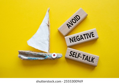 Avoid negative self-talk symbol. Concept words Avoid negative self-talk on wooden blocks. Beautiful yellow background with boat. Business and Avoid negative self-talk concept. Copy space.